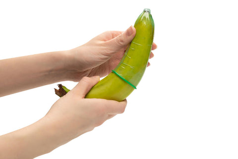 woman puts condom on banana