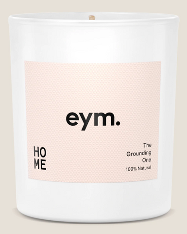 A photo of an Eym Standard candle with pink designed label stuck on