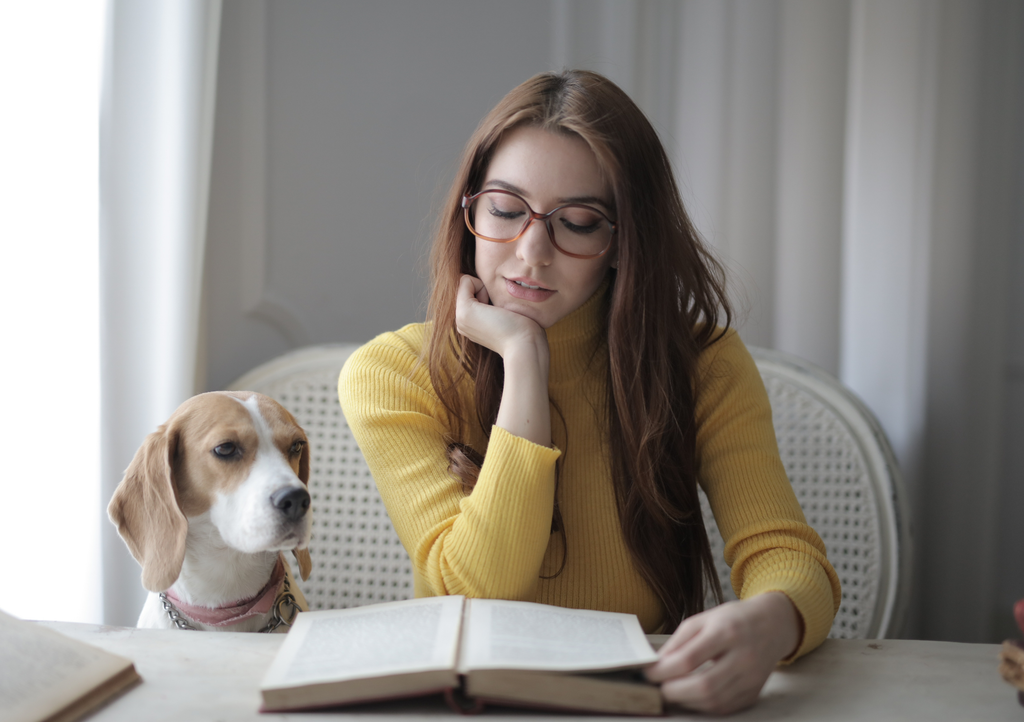 Woman reading a book with her dog