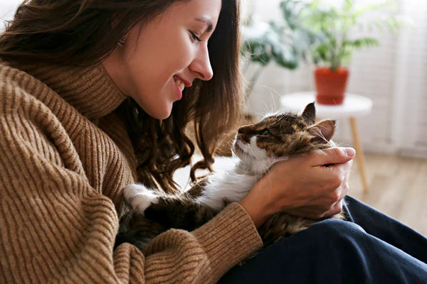 young woman playing with her cat