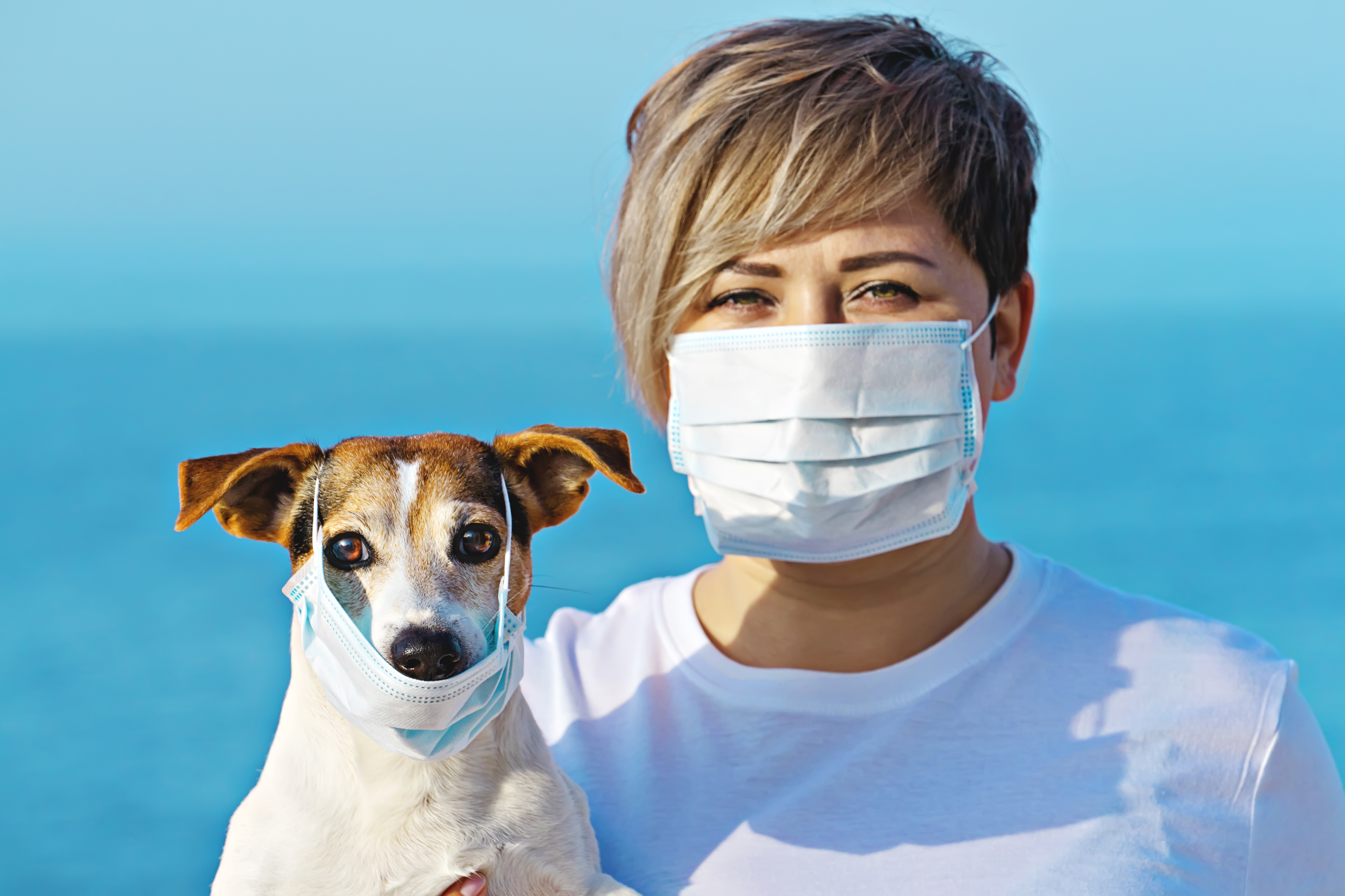 Woman and dog wearing a face mask