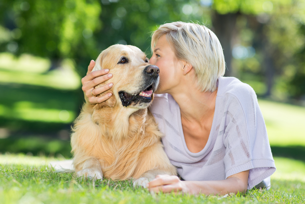 Woman kissing her dog