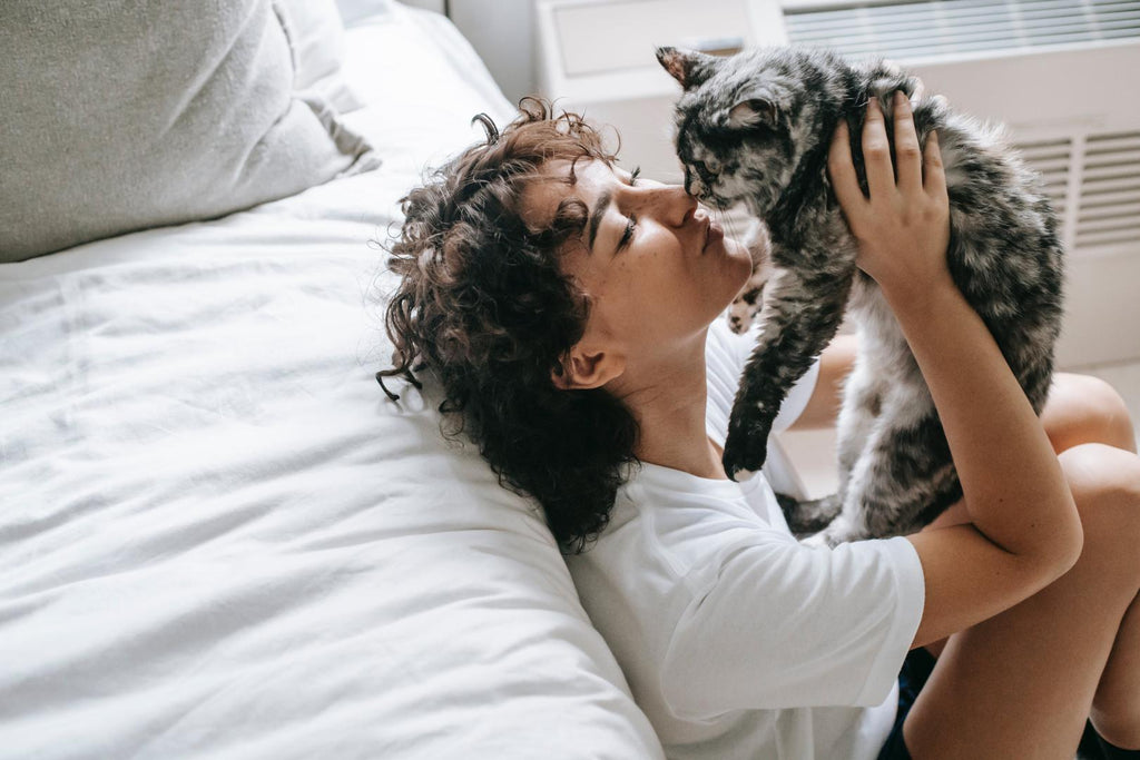 Woman kissing her cat.
