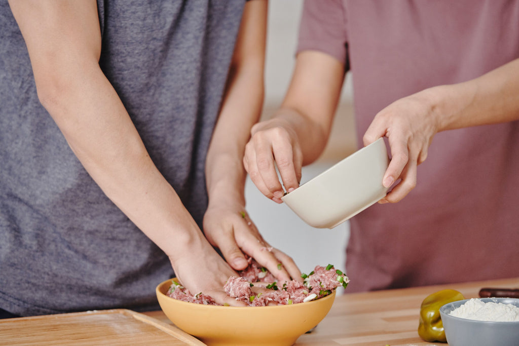 Pet parents preparing homemade raw dog food.