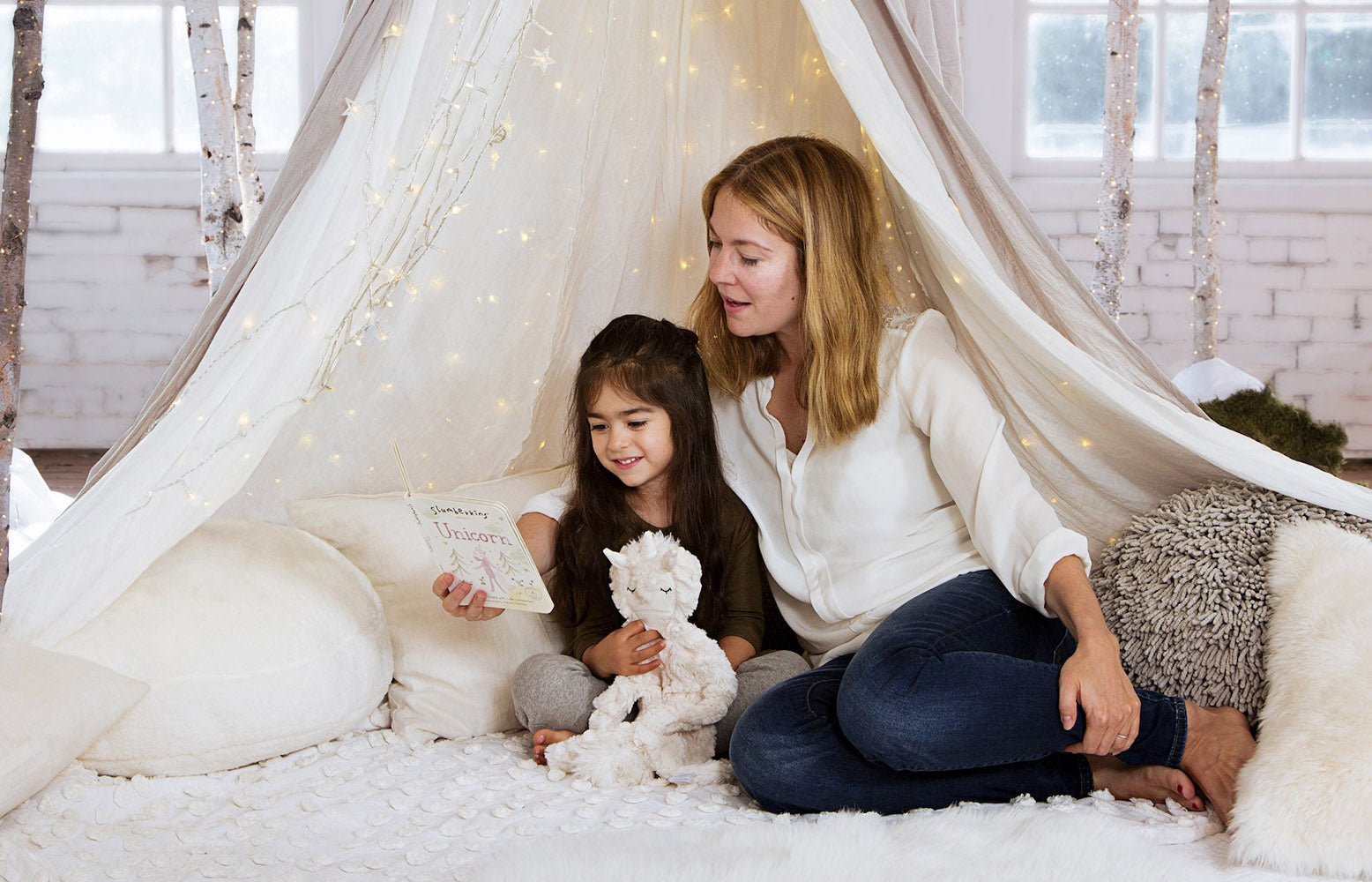 Mom and daughter reading a book in a winter wonderland