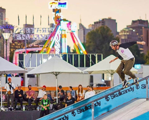 Skater Chris Pullar, is just about to land a backside on a medium sized down rail at Riverslide Skatepark. With the Moomba festival going on in the background.