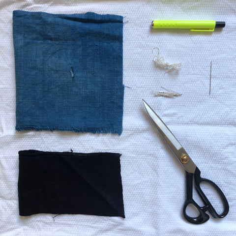 Material with hole in, patch to cover hole, chalk, thread, pins, needle and scissors