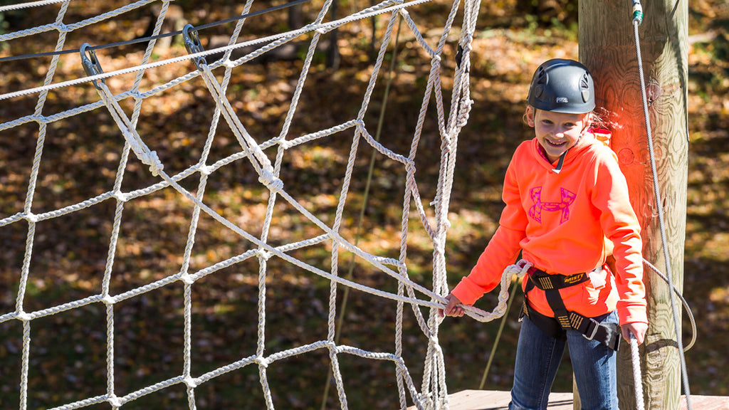 young girl on ropes course with braided, spliced lobster claw