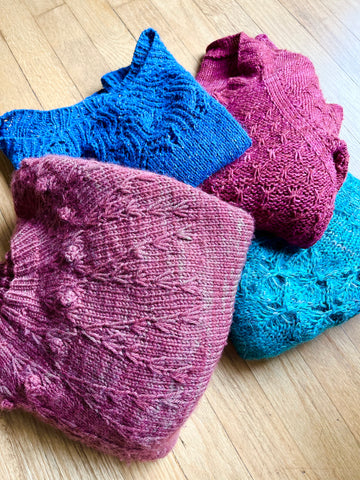 An array of hand knit sweaters