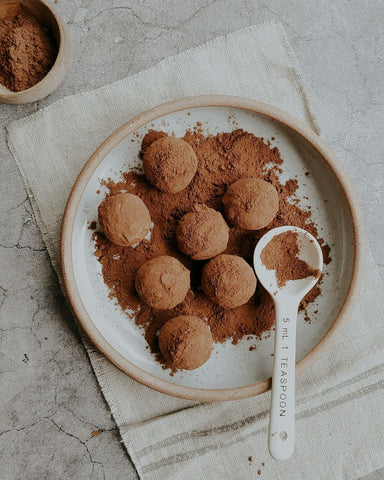 plate with protein balls covered in cacao powder with spoon