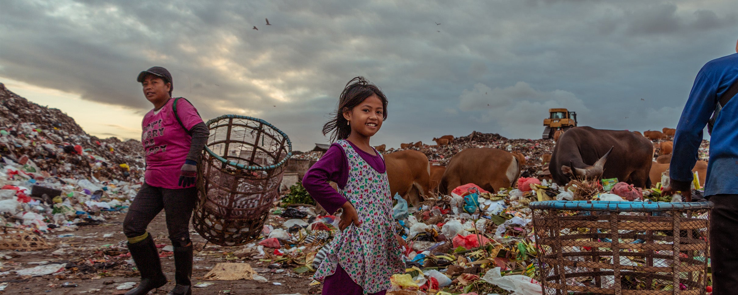 A young girl smiles for the camera despite growing up on a landfill. 