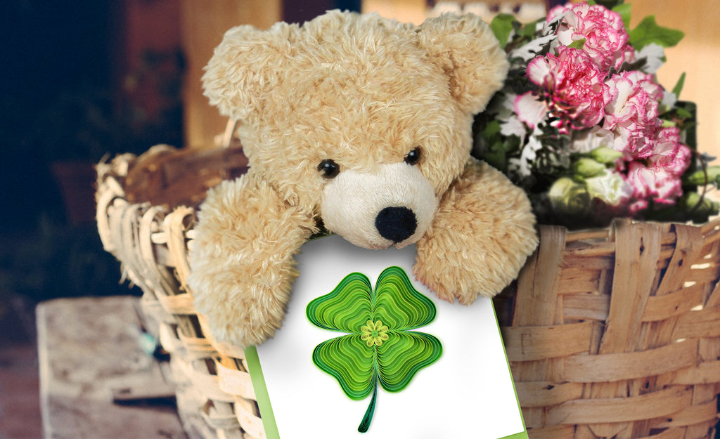 A teddy bear holding the Quilled Four Leaf Clover Card. 