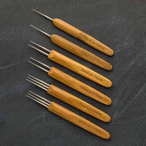 6 different bamboo crochet hooks laid together on a flat surface