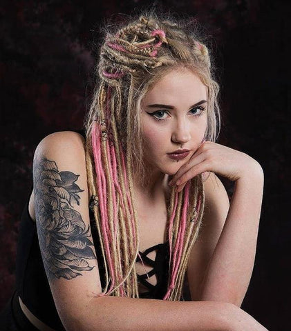 girl with dreadlocks sat and resting hand on chin