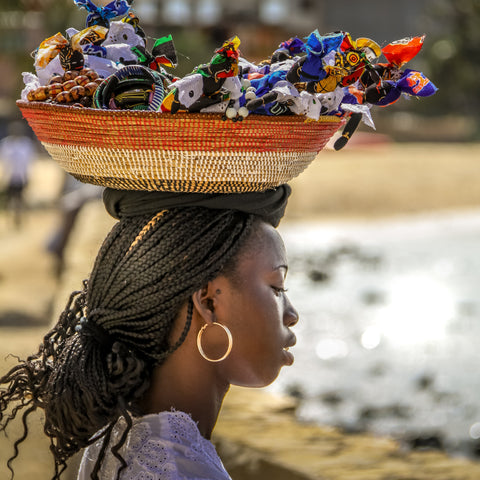 A beautiful Cape Verdian woman, carrying a basket of trinkets on her head, to sell to the tourist