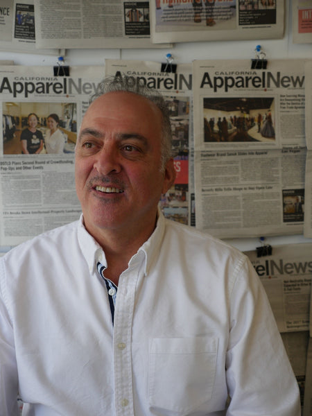 man being interviewed in front of a wall of news papers