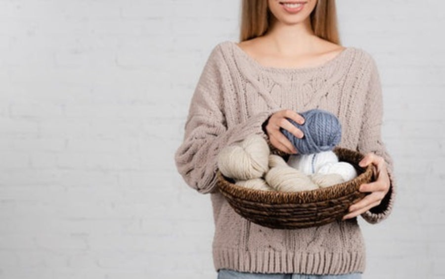 a woman holding a basket of yarn thread