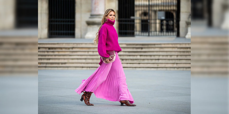 a woman in a pink dress is walking down the street