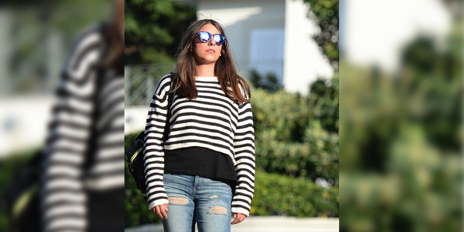 a woman standing next to a wall with a skateboard