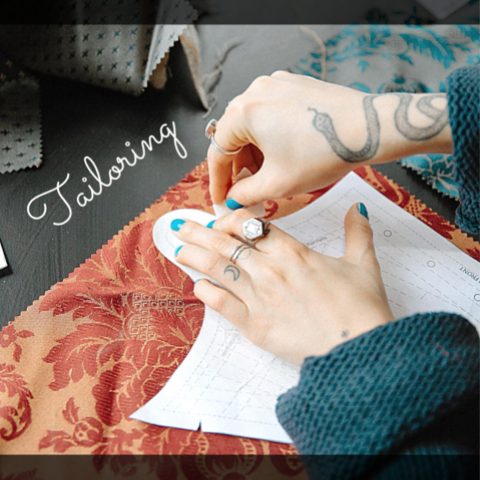 woman with tattoos sewing fabric