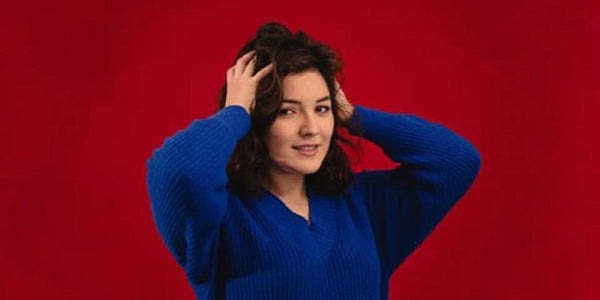 women wearing blue sweater with red background