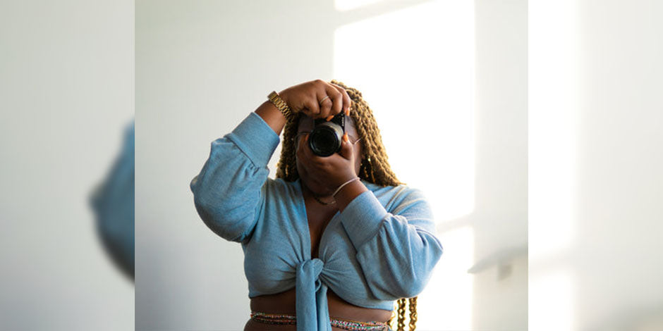 women wearing blue top holding a DSLR