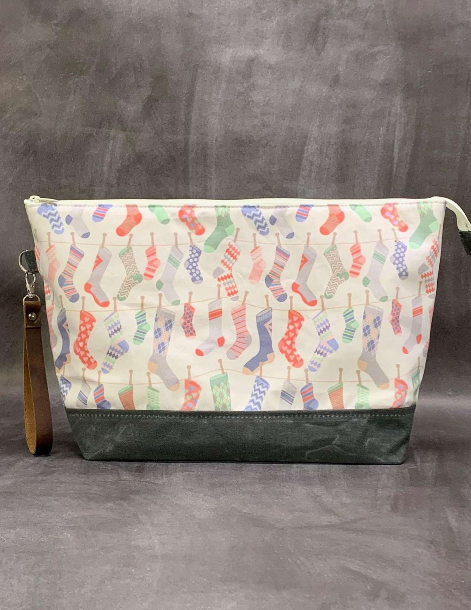 A project bag with zip made in a fabric print of hanging socks
