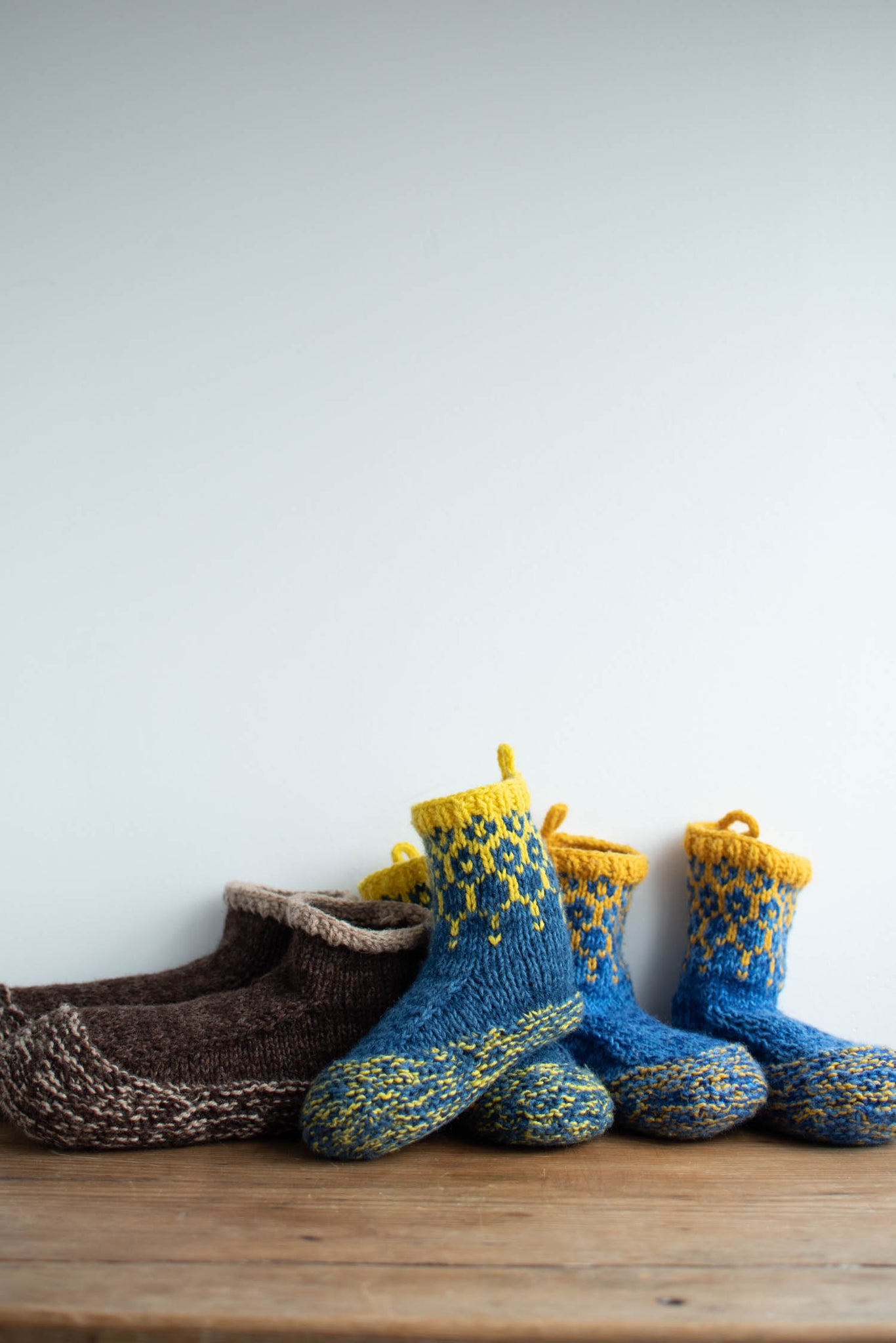 3 pairs of slippers, 2 in slightly different tones of blue and yellow, 1 in brown and beige