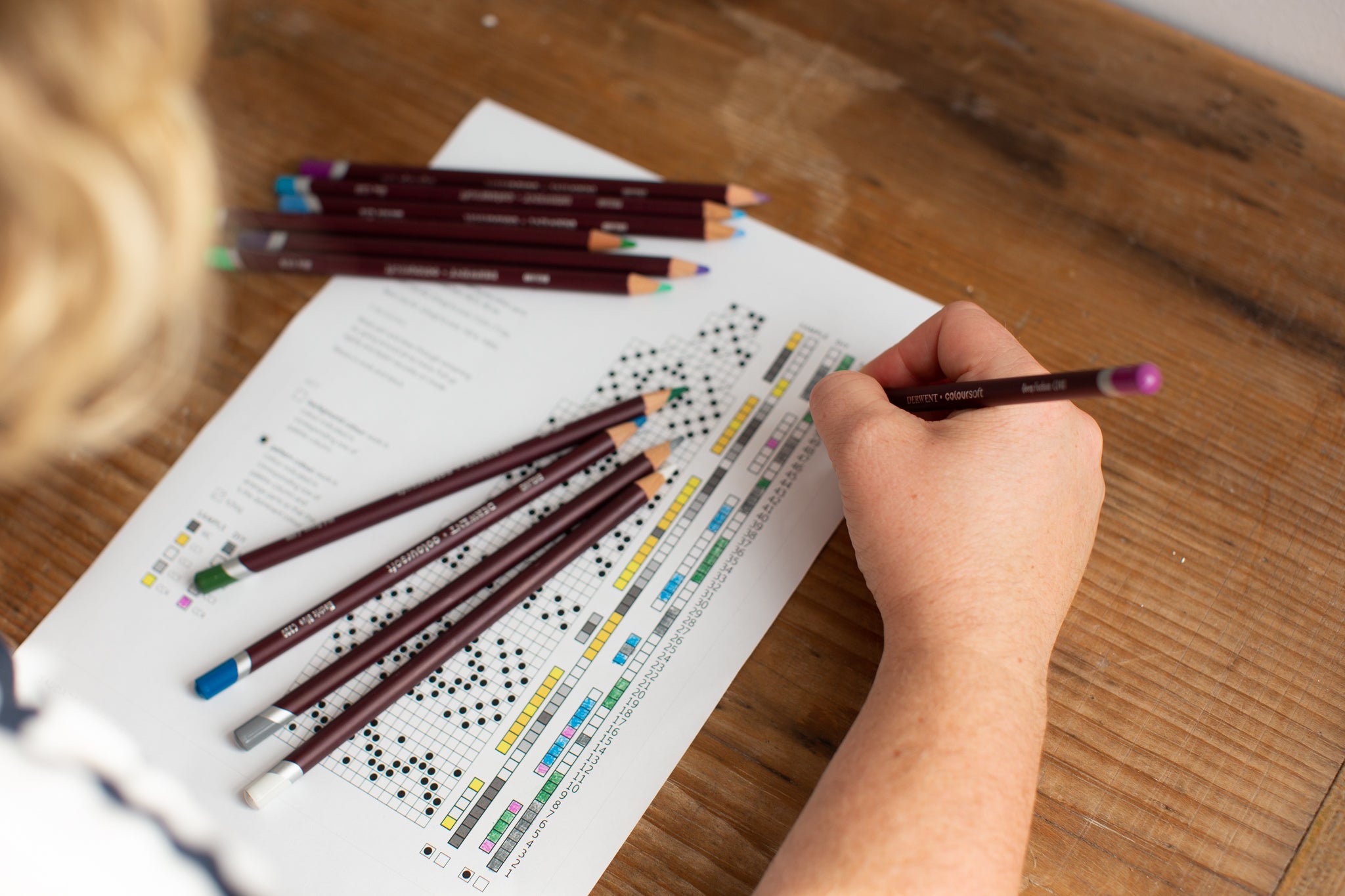 Bex colouring the custom chart key for saudade with coloured pencils