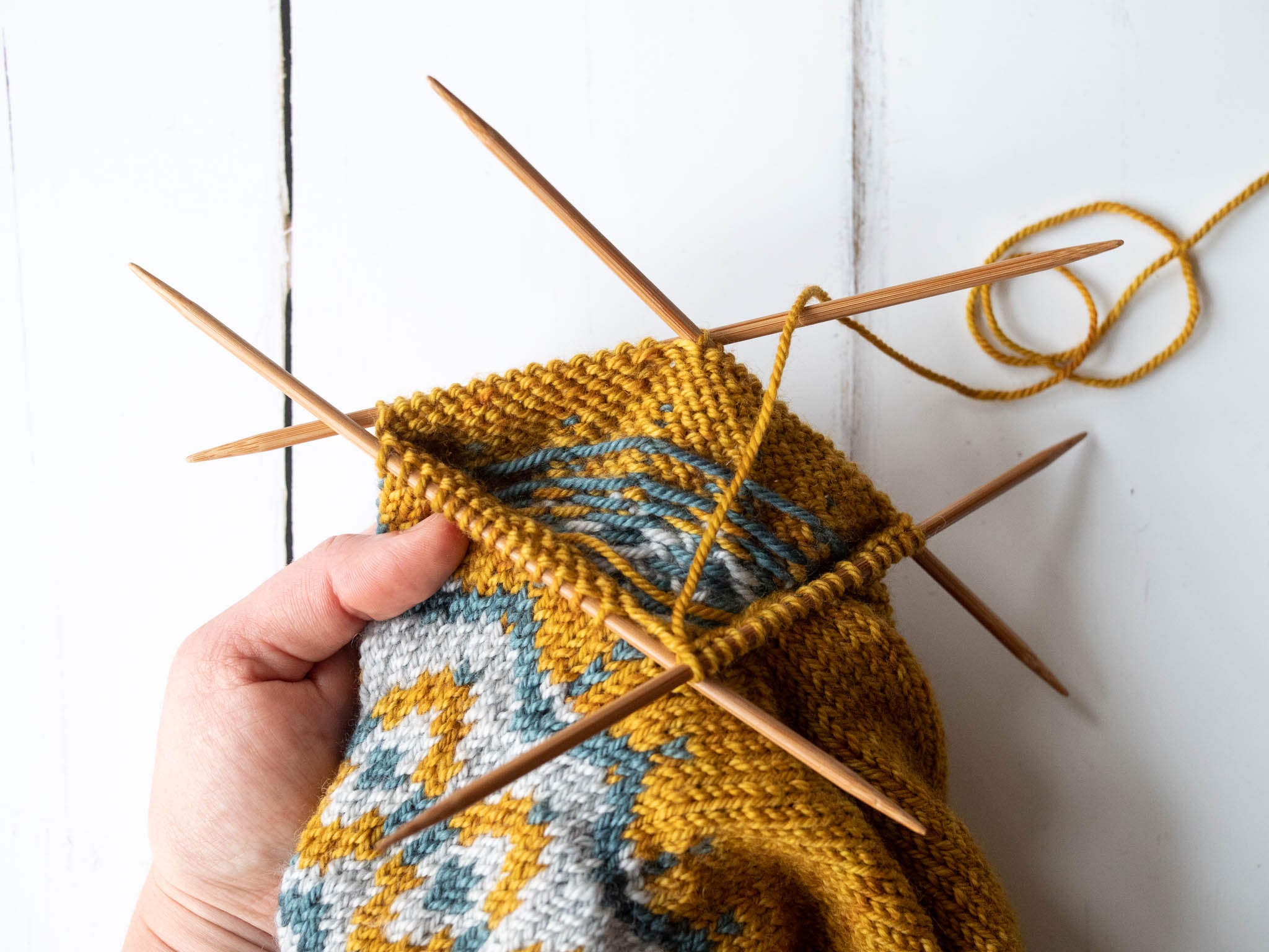 the sleeve of a colourwork sweater on double pointed needles