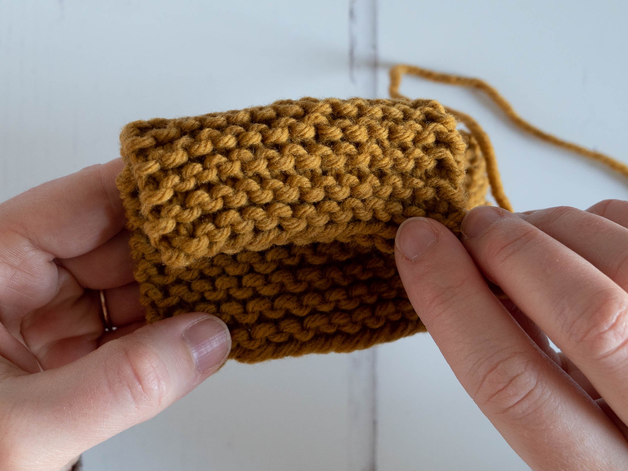 a garter stitch swatch folded over to show both sides