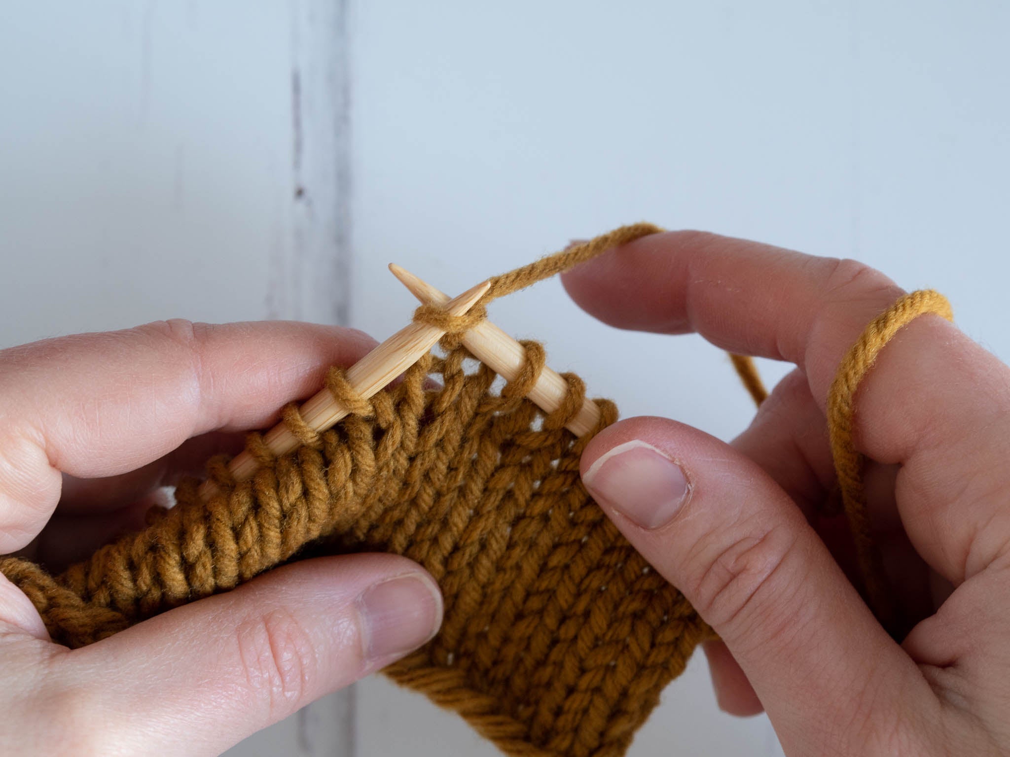 working a knit stitch; right needle tip in stitch with yarn wrapped