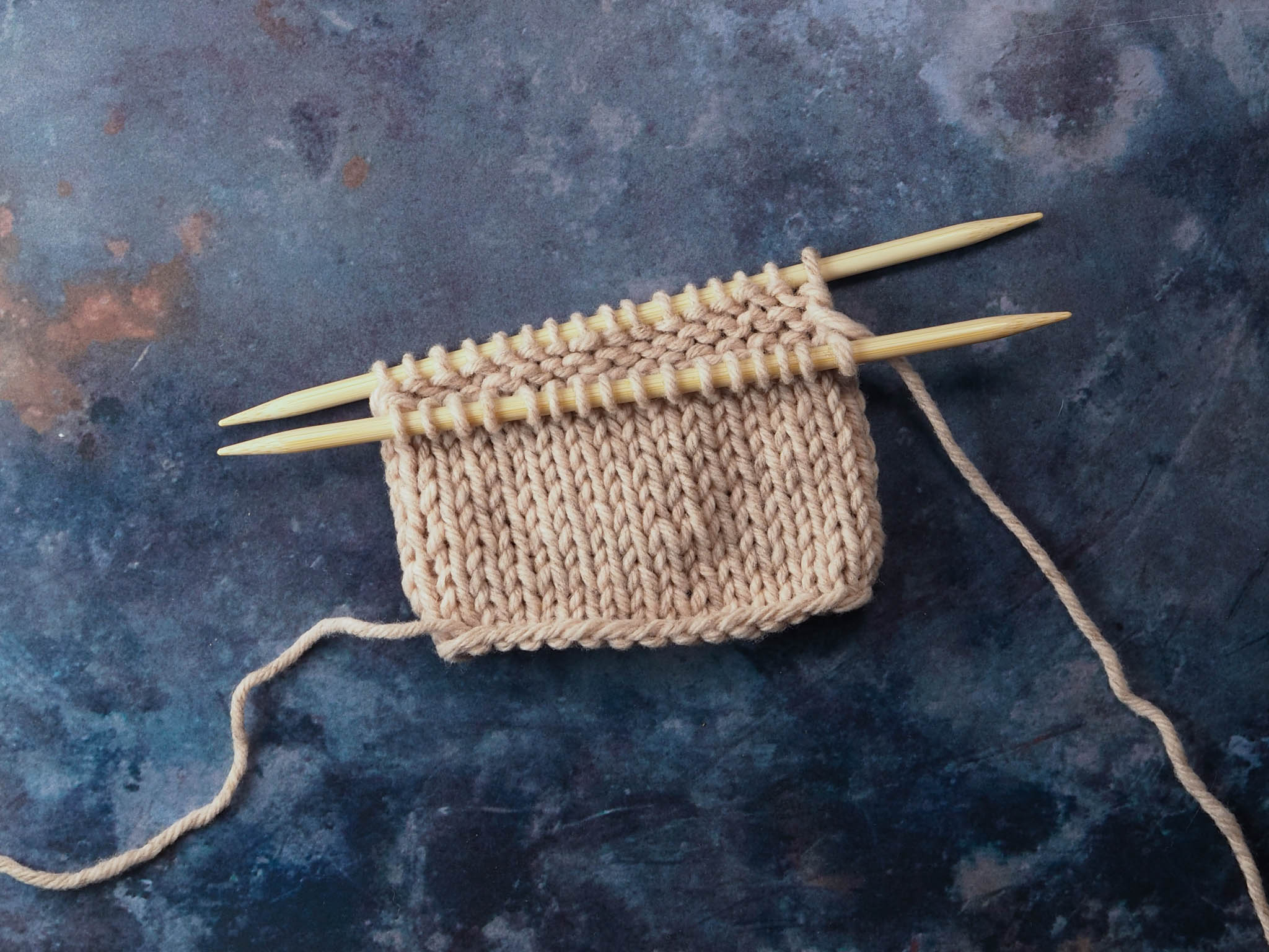 A tube of stockinette stitch, split over 2 double pointed needles, ready to graft.