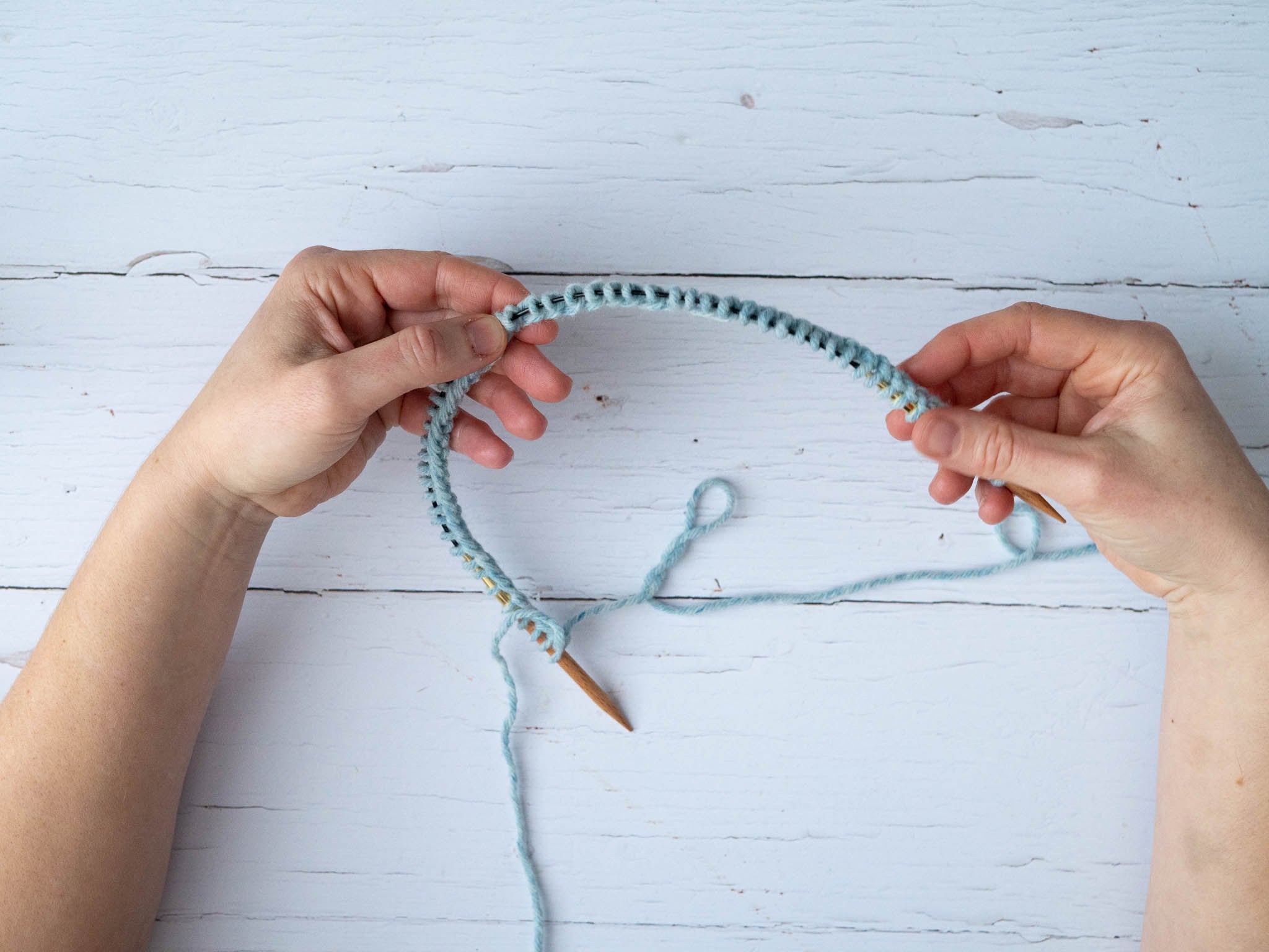 a circular needle with stitches cast on in blue yarn