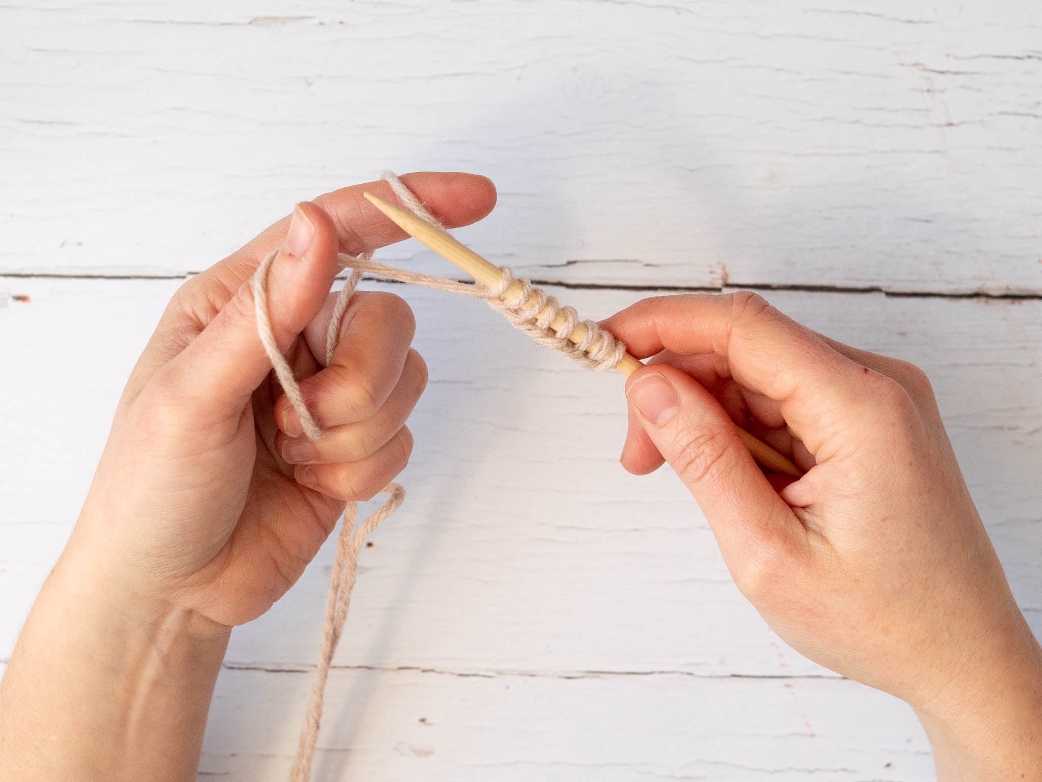 pink yarn being cast on onto one needle