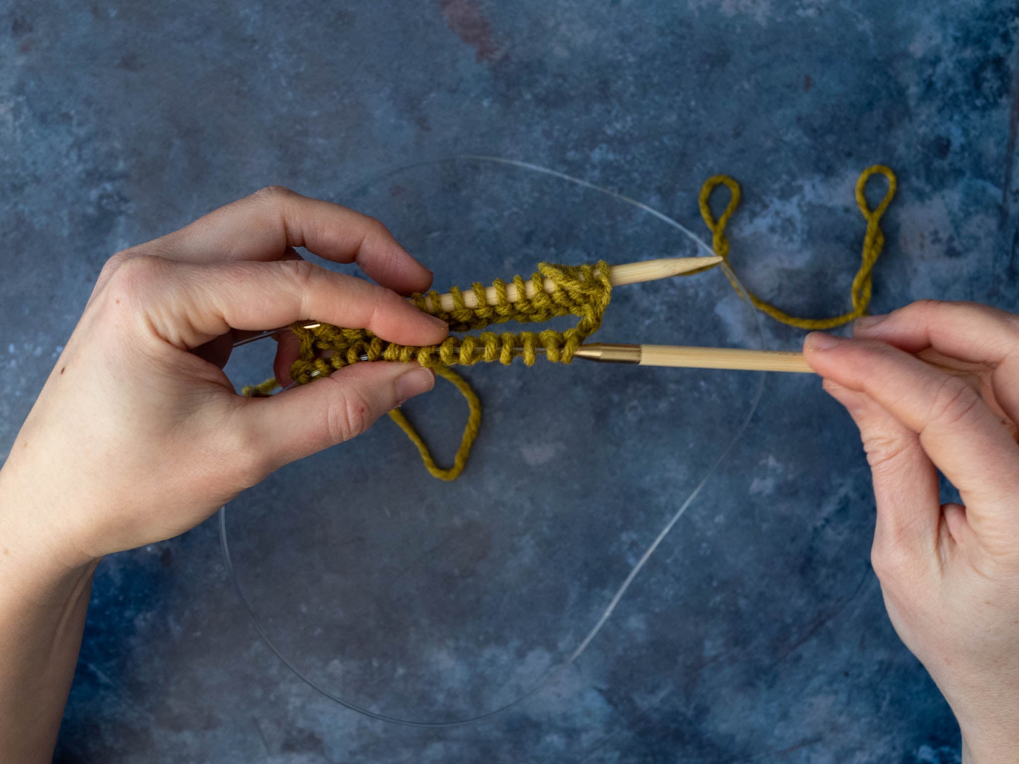 the front stitches are being slid onto the empty needle tip