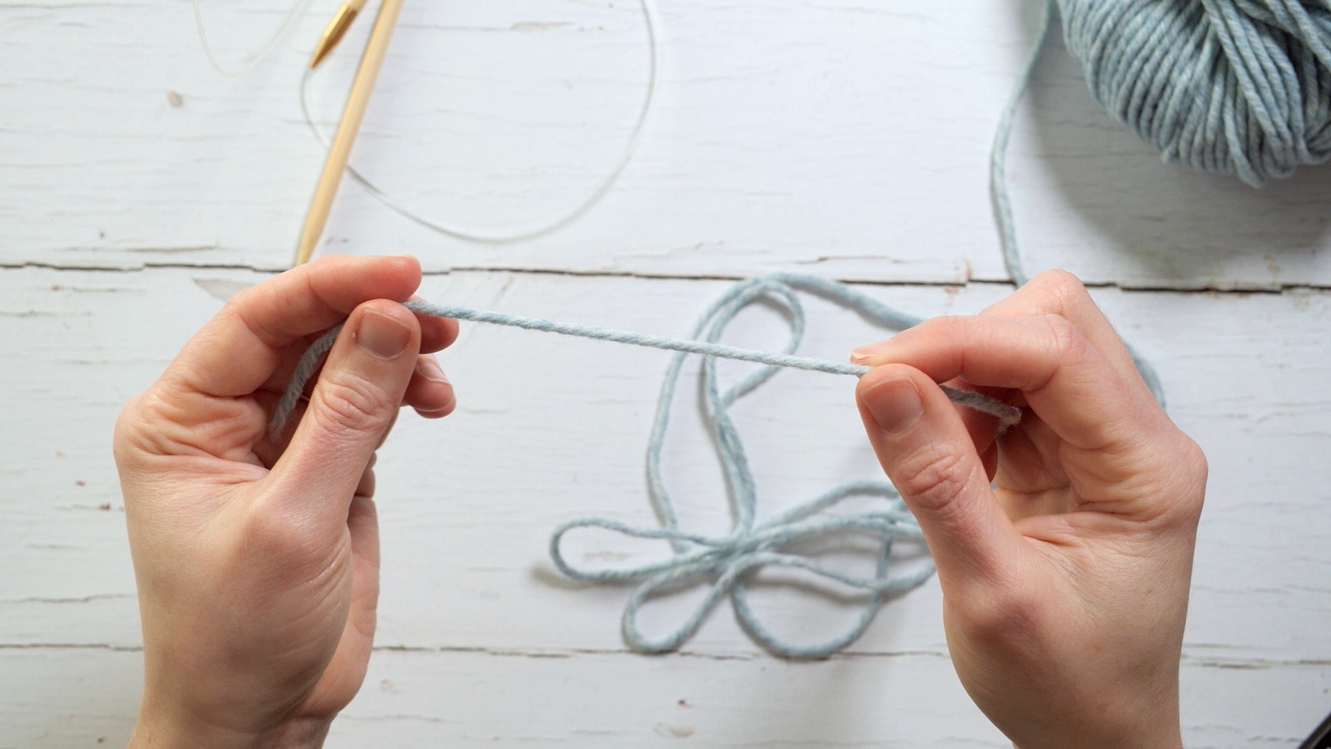 a short length of yarn is held between two hands