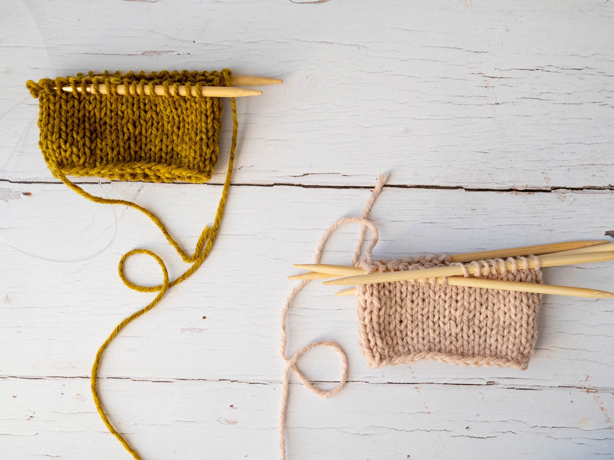a gold swatch on a long circular needle and a pink one on double pointed needles