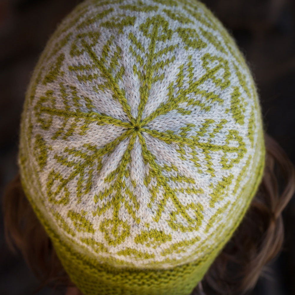 close up of the crown of the hat, in green and grey. The leaf motifs come together like a snowflake in the centre.