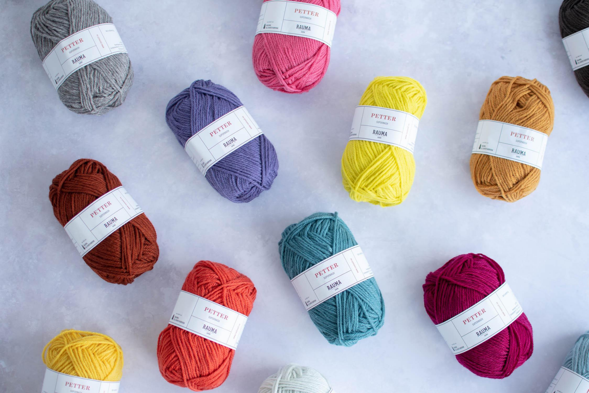 brightly coloured balls of yarn arranged on a table