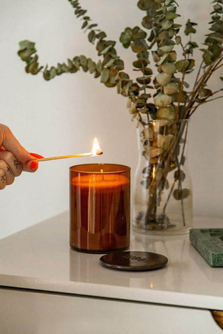 person holding match to light candle