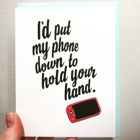 Greeting card that says "I'd put my phone down to hold your hand" next to a picture of a cell phone
