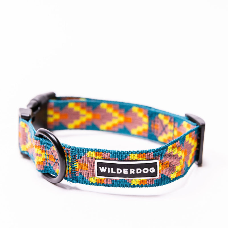Introducing our Havasu Ultralight Collar: a vibrant dog collar showcasing a geometric pattern in blue, yellow, and orange tones. Made from ultralight nylon webbing, it includes a metal D-ring and a plastic buckle. The brand name "Wilderdog" is elegantly displayed on a black label.