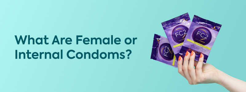 Image of a hand holding female (internal) condoms on a teal background