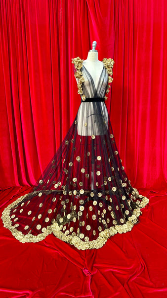 Black toole dress decorated with condoms in the shape of medallions and roses all spray painted gold leading up the dress and around the shoulders