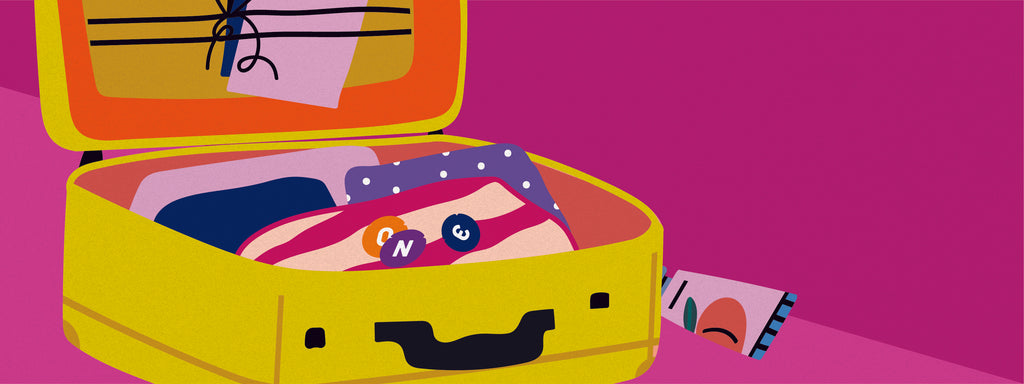 A suitcase packed with clothes with three ONE Condoms on top.