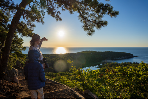 Child and parent looking at a beautiful view after doing a hike or trek together. 