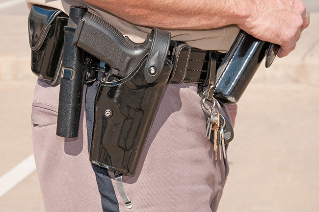Police officer showing off his tactical belt with holster and more