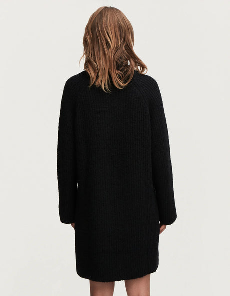 The back view of a woman wearing a Denham ELLE Dress - Black alpaca-blend sweater dress.