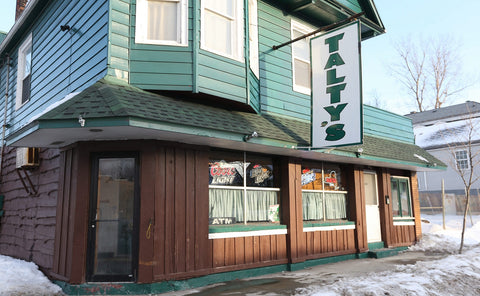 Talty's Tavern in Buffalo. Home to the world's shortest St. Patty's Day Parade. It's a brick building, with big windows and a green, wood paneled upper half, with a sign hanging from a bar that reads Talty's